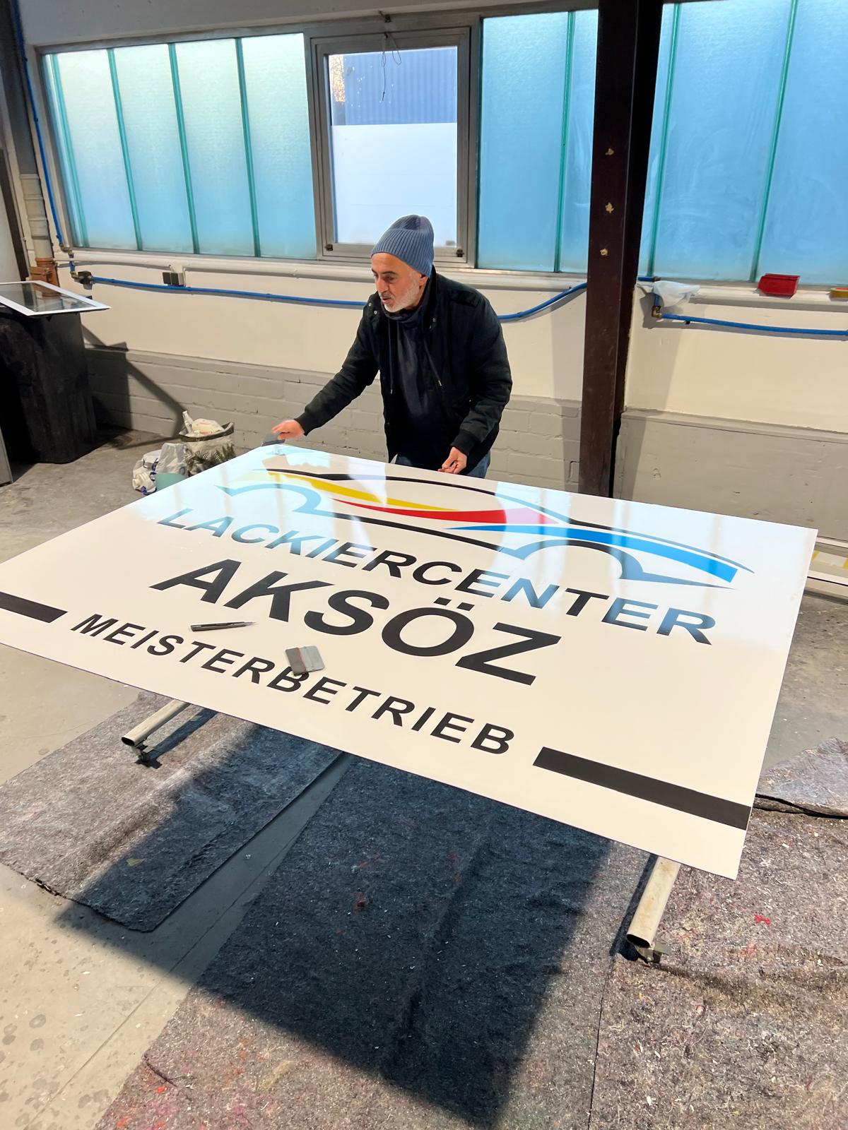 Lackiercenter Aksöz Meisterbetrieb – großformatiges Werbeschild im Druckprozess